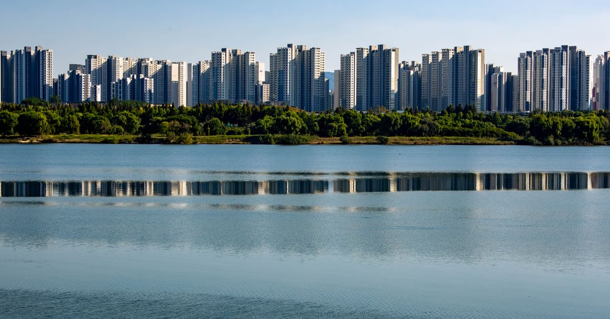 Skyline of modern residential towers reflecting in the peaceful Han River in Seoul, South Korea.